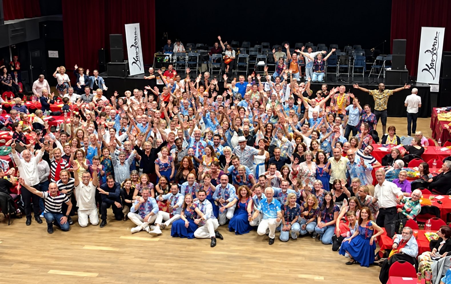 Grande assemblée d’adhérents de Mouv’Danse, bras levés, lors du gala